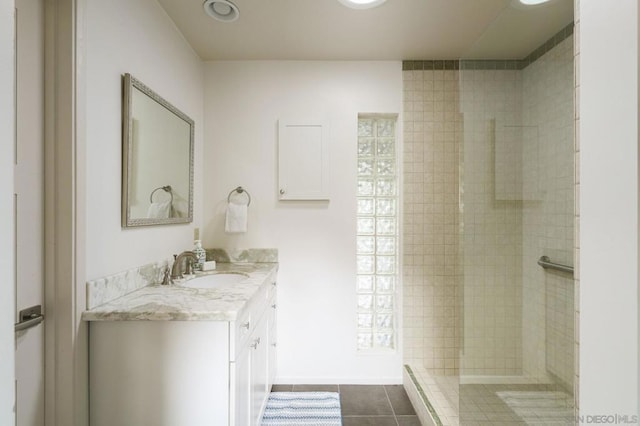 bathroom with tile patterned floors, vanity, and tiled shower