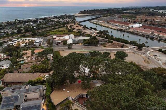 aerial view at dusk featuring a water view