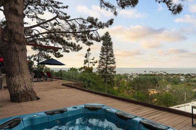 pool at dusk featuring a water view