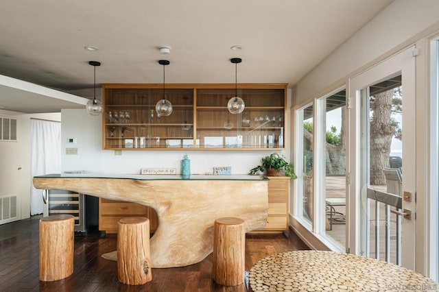 bar featuring light brown cabinets and dark hardwood / wood-style flooring