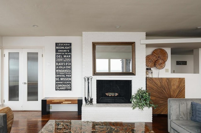 living room with dark hardwood / wood-style floors, a fireplace, and french doors