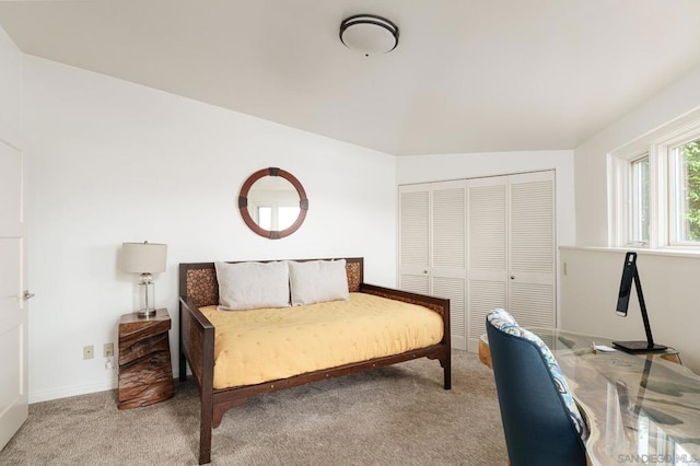 carpeted bedroom featuring a closet and lofted ceiling