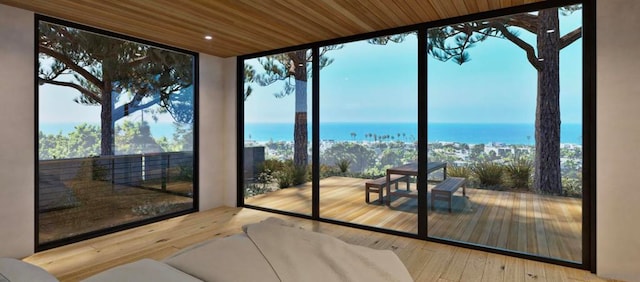 entryway with a wall of windows, a water view, wooden ceiling, and hardwood / wood-style flooring