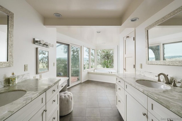 bathroom with tile patterned flooring, vanity, and a bath