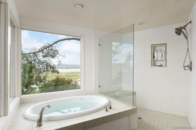 bathroom featuring tile patterned floors, separate shower and tub, a water view, and a wealth of natural light