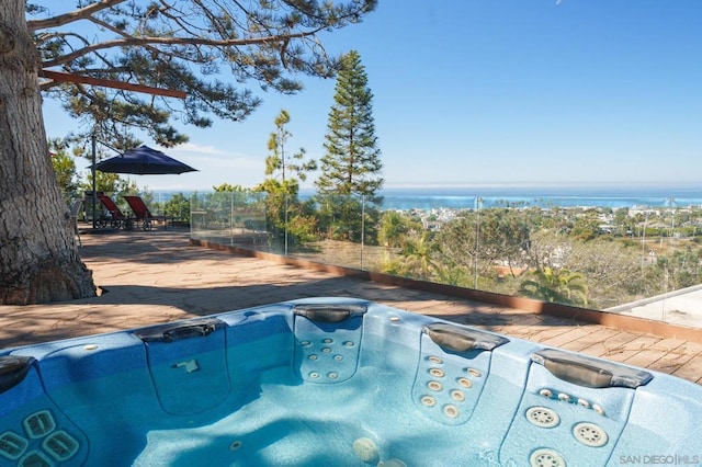 view of pool with a water view and an outdoor hot tub