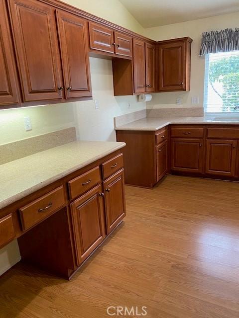 kitchen with light hardwood / wood-style flooring, lofted ceiling, and sink