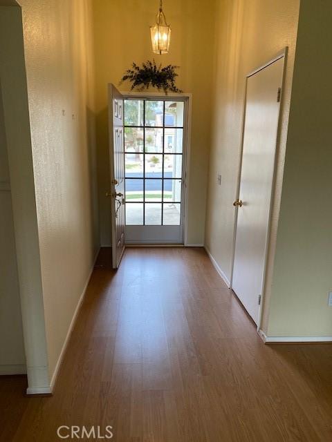 doorway to outside featuring hardwood / wood-style floors and an inviting chandelier