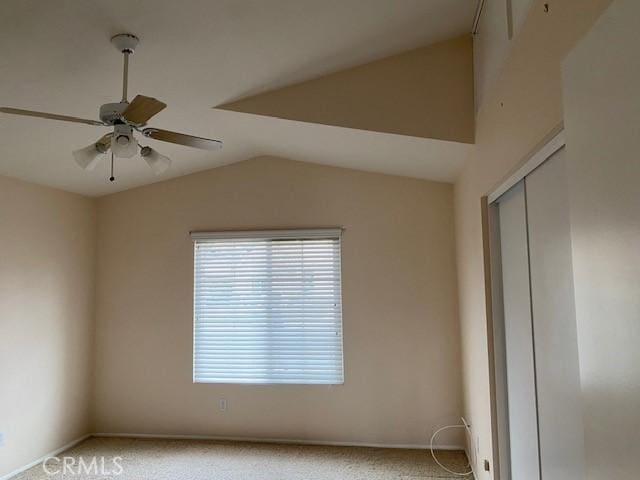 empty room featuring ceiling fan, light carpet, and vaulted ceiling