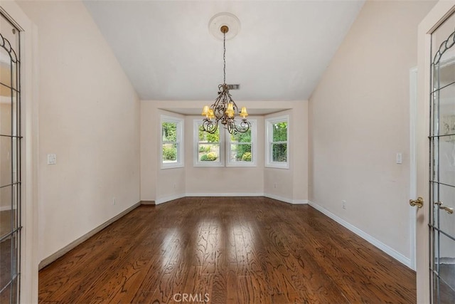 unfurnished dining area with dark hardwood / wood-style flooring, lofted ceiling, and an inviting chandelier