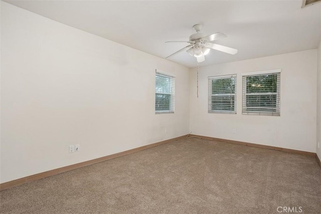 spare room featuring ceiling fan and carpet