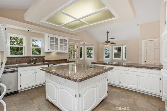 kitchen featuring vaulted ceiling, ceiling fan, sink, white cabinets, and a kitchen island