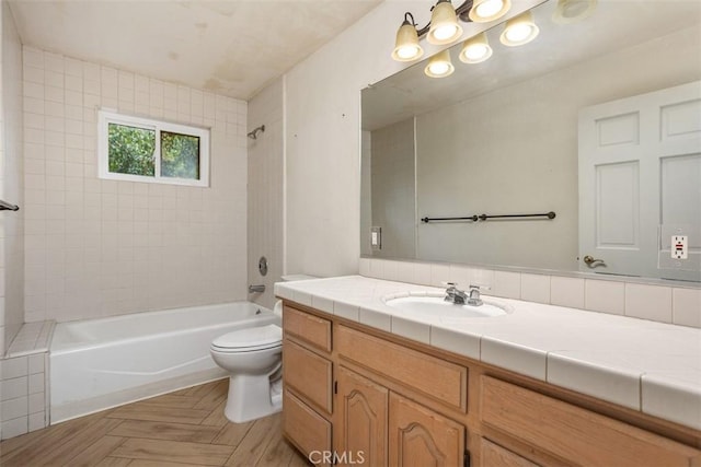 full bathroom featuring tiled shower / bath, vanity, parquet floors, and toilet