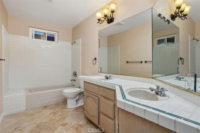 full bathroom with vanity, tiled shower / bath combo, and toilet