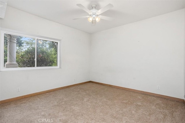 carpeted spare room with ceiling fan