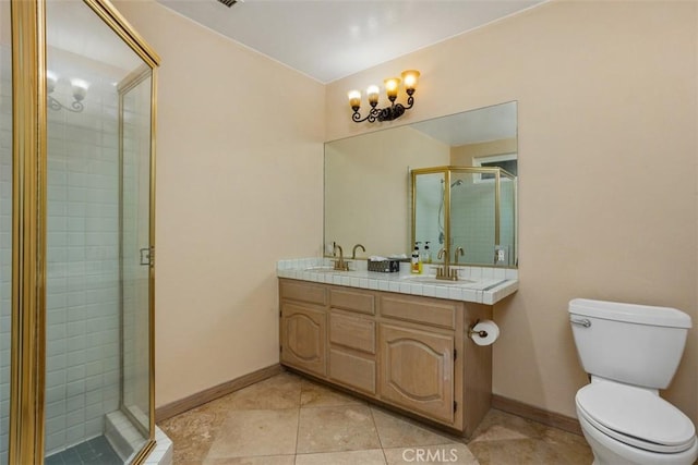 bathroom with tile patterned floors, vanity, an enclosed shower, and toilet