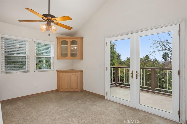 empty room featuring french doors, light colored carpet, ceiling fan, and lofted ceiling