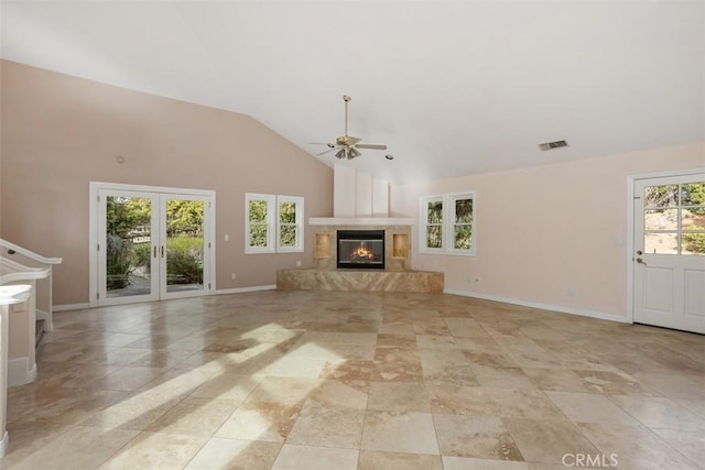 unfurnished living room featuring plenty of natural light, ceiling fan, a fireplace, and high vaulted ceiling