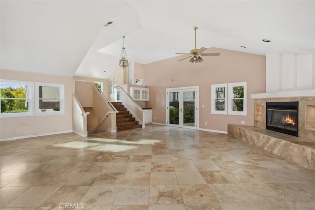 unfurnished living room featuring ceiling fan, a premium fireplace, and high vaulted ceiling