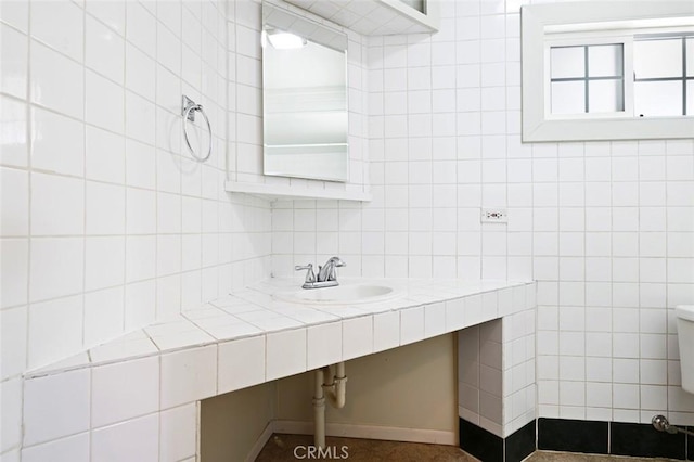 bathroom featuring sink and tile walls