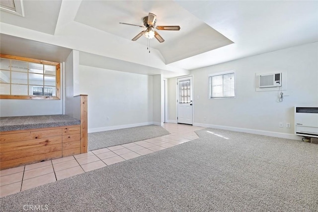 unfurnished living room featuring a raised ceiling, a wall mounted air conditioner, light carpet, and ceiling fan