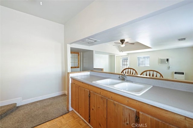 kitchen with ceiling fan, light parquet flooring, and sink