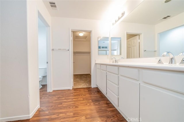 bathroom featuring toilet, hardwood / wood-style floors, and vanity