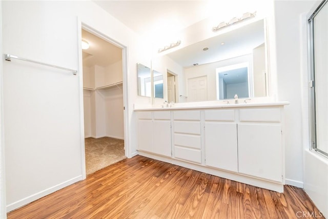 bathroom featuring hardwood / wood-style floors, combined bath / shower with glass door, and vanity