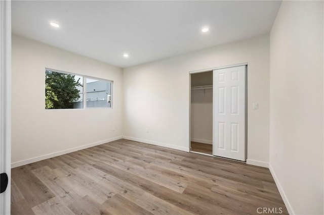 unfurnished bedroom featuring a closet and light hardwood / wood-style flooring