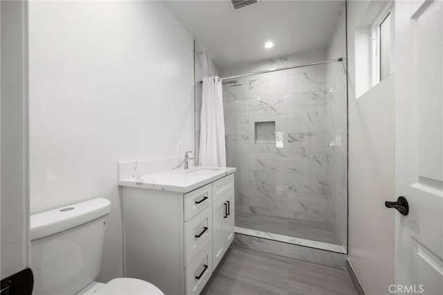 bathroom featuring a shower with shower curtain, vanity, and toilet