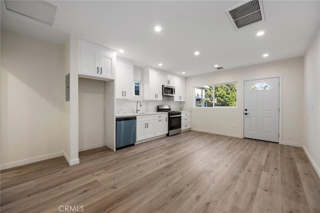 kitchen with light hardwood / wood-style floors, sink, white cabinetry, and stainless steel appliances