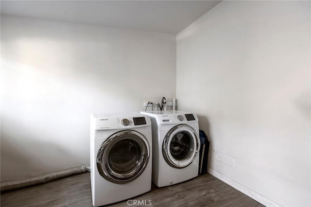 laundry area featuring washing machine and dryer and dark hardwood / wood-style flooring