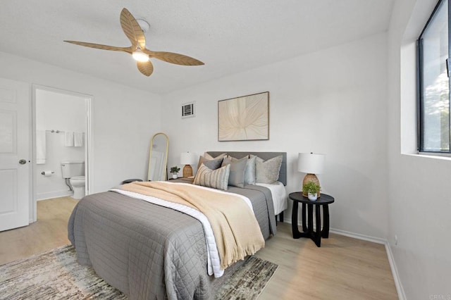 bedroom with light wood-style floors, baseboards, connected bathroom, and a ceiling fan