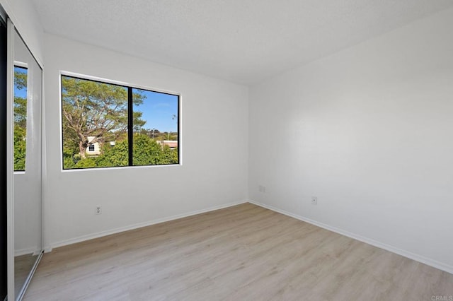 unfurnished room featuring light wood-style flooring and baseboards