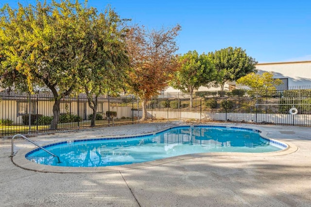 community pool featuring fence and a patio