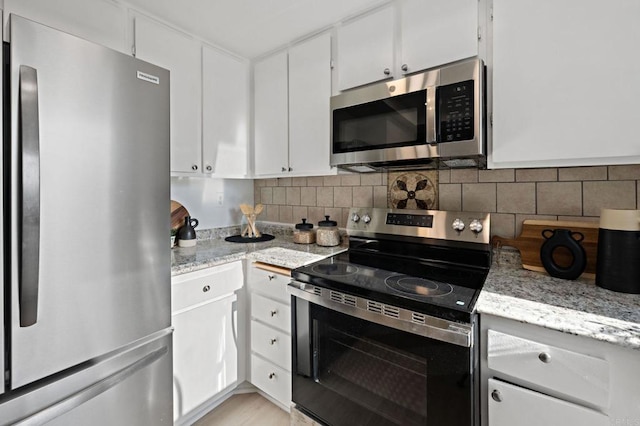 kitchen with appliances with stainless steel finishes, white cabinetry, and decorative backsplash