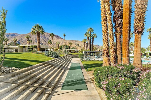 surrounding community with a mountain view and a yard