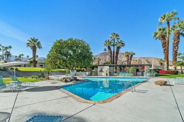 view of swimming pool with a mountain view and a patio area