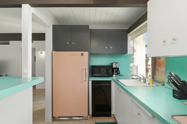 kitchen featuring sink, white fridge, white cabinetry, and light tile patterned flooring