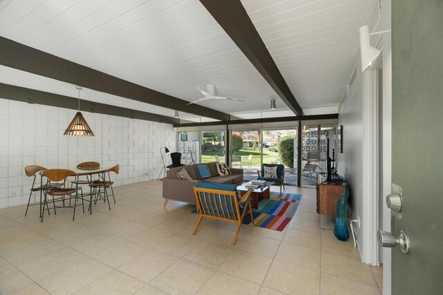 interior space featuring beam ceiling, light tile patterned floors, tile walls, and ceiling fan