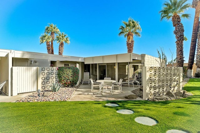 back of house with a patio area and a yard