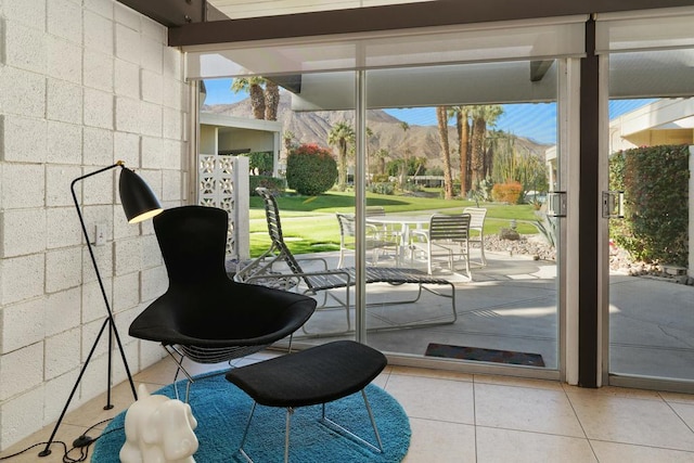 doorway to outside featuring a mountain view, light tile patterned floors, and a healthy amount of sunlight