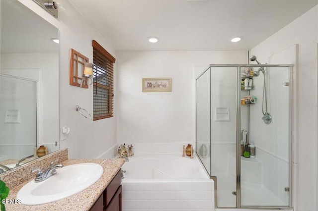 bathroom with vanity and shower with separate bathtub