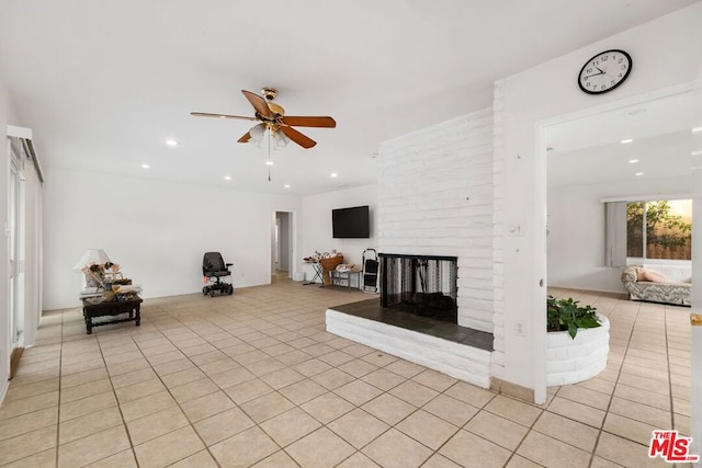 unfurnished living room featuring light tile patterned floors, a brick fireplace, and ceiling fan