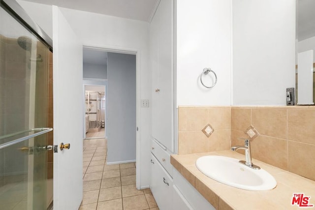 bathroom with sink, a shower with shower door, and tile patterned flooring