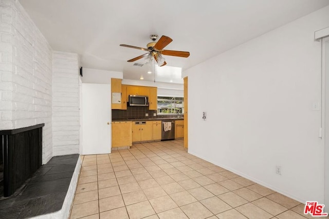 kitchen with tasteful backsplash, stainless steel appliances, ceiling fan, light tile patterned floors, and a fireplace