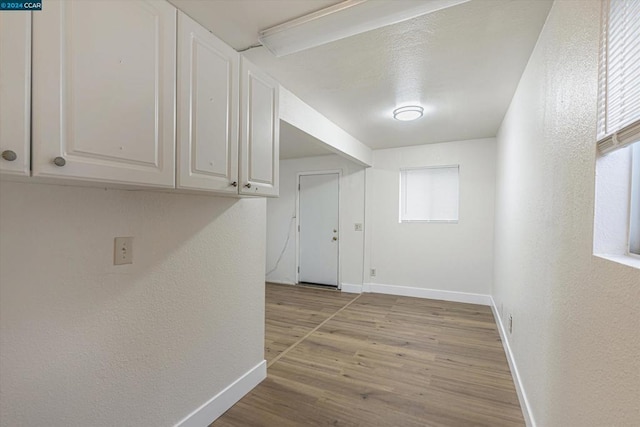 hallway with light hardwood / wood-style floors