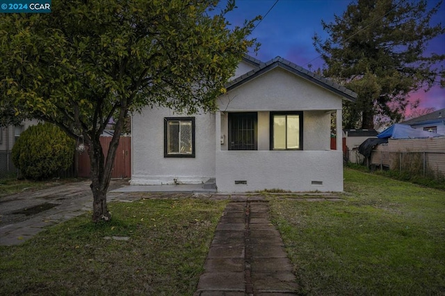 bungalow-style home with a lawn