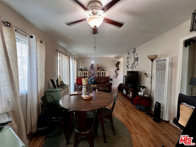 dining area with ceiling fan, a textured ceiling, and hardwood / wood-style flooring