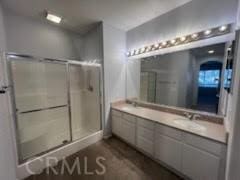 bathroom featuring walk in shower and vanity